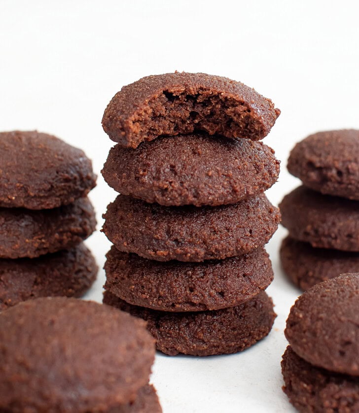 A stack of Chocolate Cottage Cheese Cookies with a bite taken from the top cookie