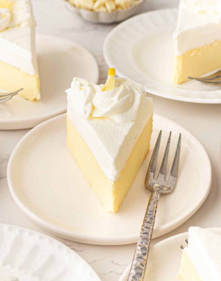 A slice of Lemon Yogurt Cheesecake on white plate with a fork