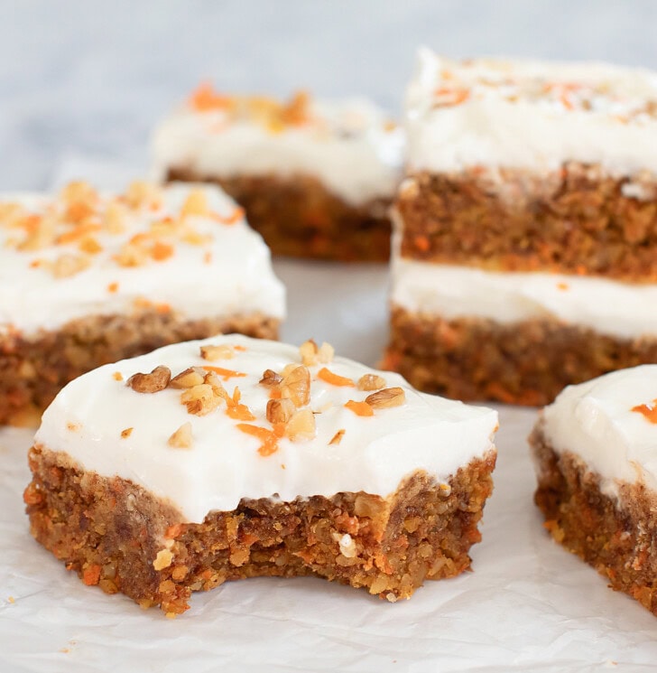 No Bake Carrot Cake Bars topped with frosting, chopped walnuts and shredded carrots