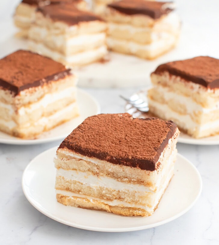 Slices of Tiramisu Cheesecake on white plates