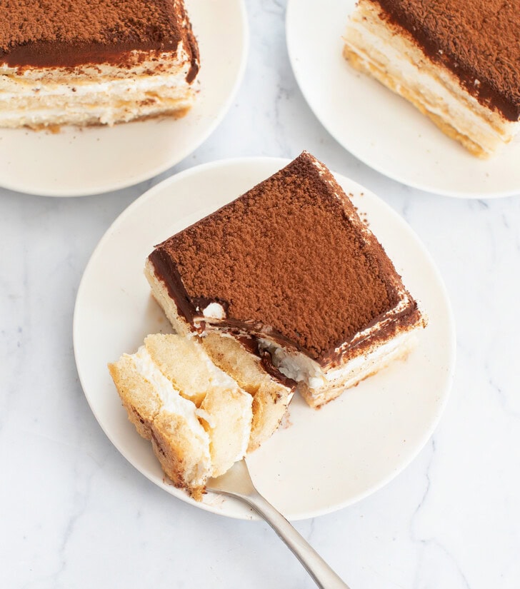 A slice of No Bake Tiramisu Cheesecake with a bite on a fork