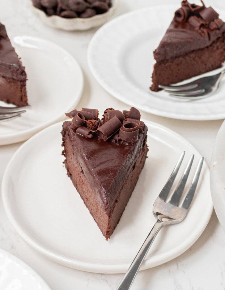 A slice of chocolate cake on a white plate with a fork