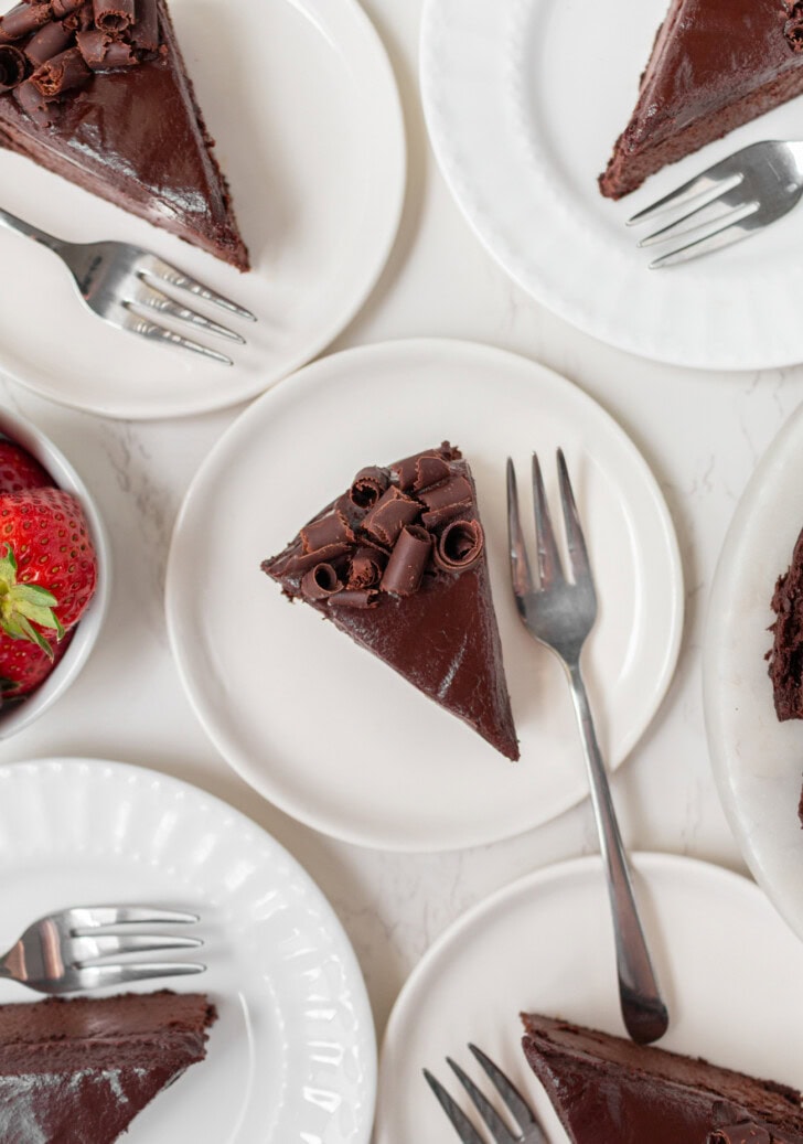 Chocolate cake slices on white plates with forks