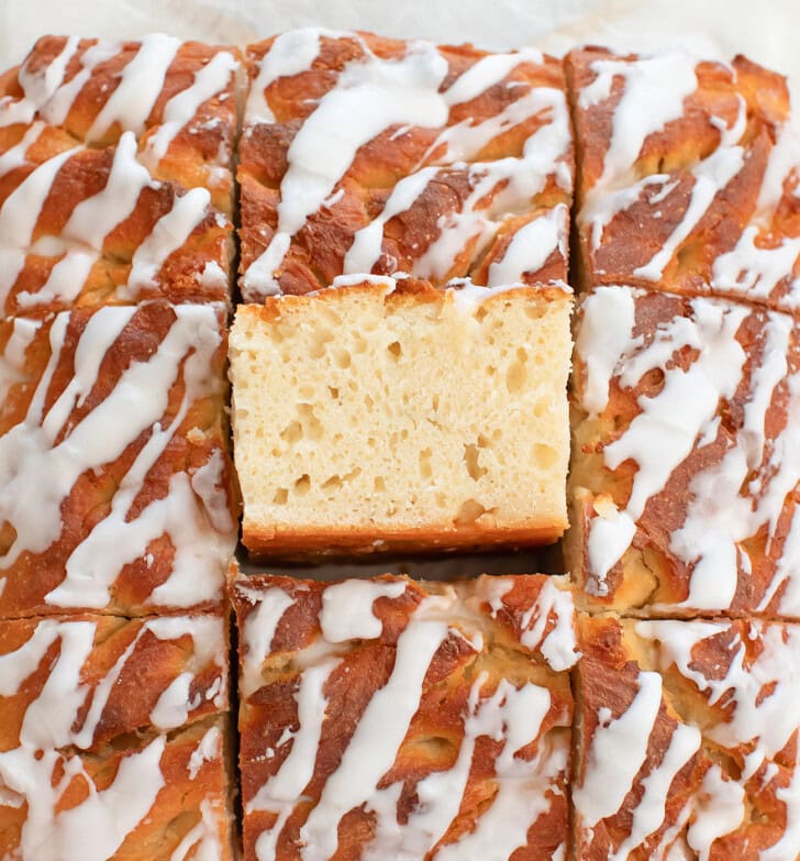 Donut Focaccia cut into squares with a glaze drizzled on top