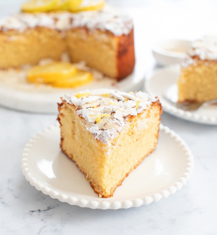 A slice of almond cake on a small white plate