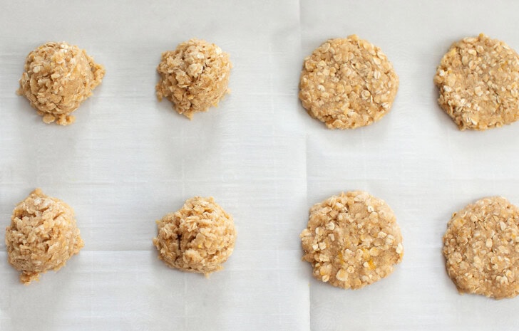 Cookie dough scooped onto a baking sheet and then flattened