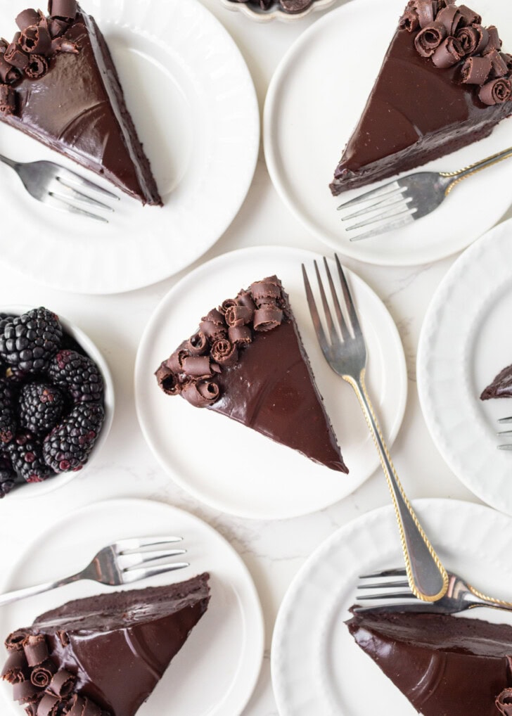Slices of chocolate cake on plates with forks