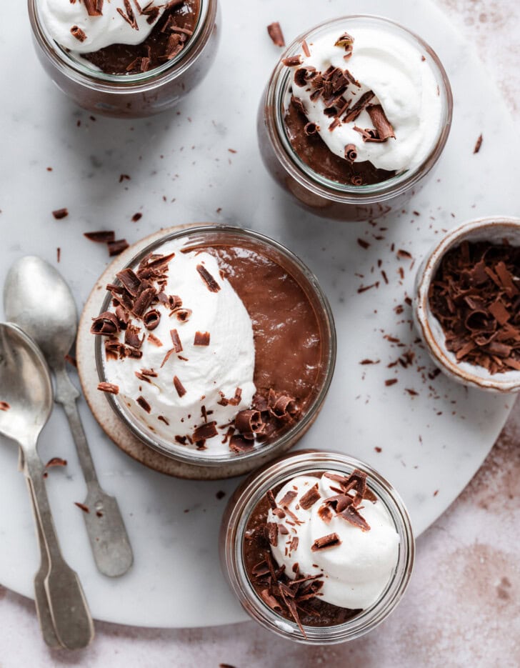 Chocolate mousse cups topped with whipped cream and chocolate shavings
