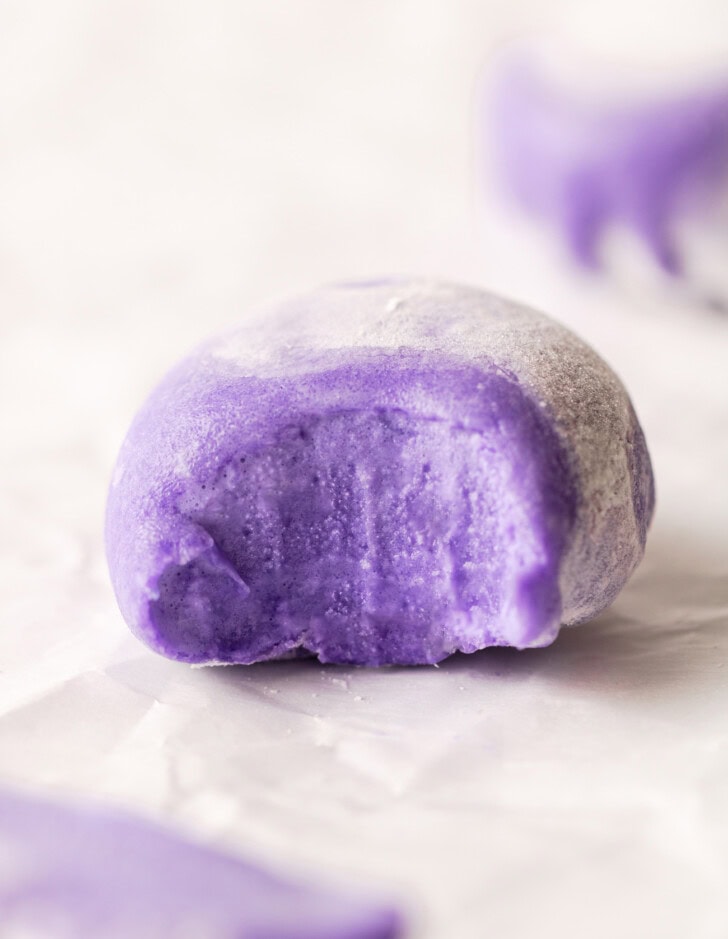 A bite taken from a piece of mochi ice cream