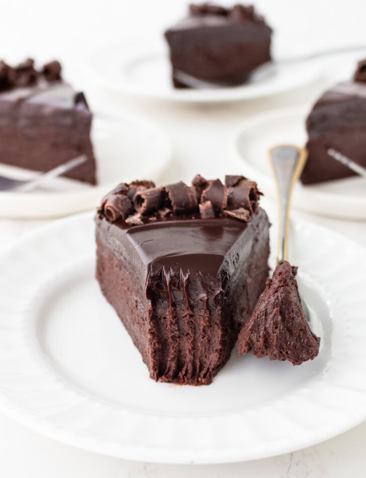 A bite taken from a slice of chocolate cake