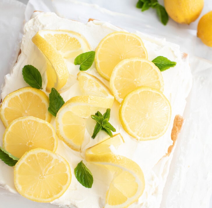 A no bake lemon yogurt cheesecake with lemon slices and herbs on top