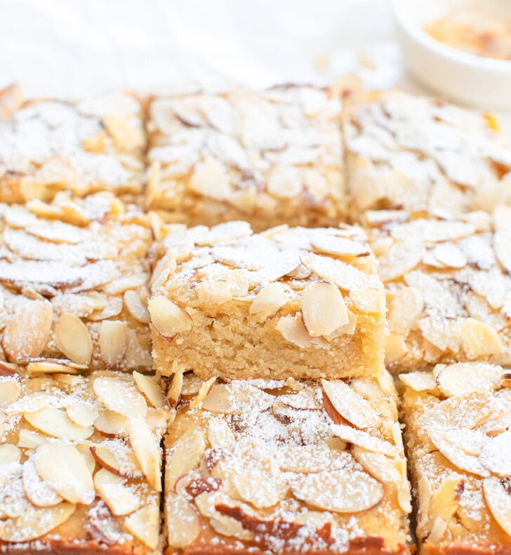 Almond bars topped with sliced almonds and dusted with powdered sugar