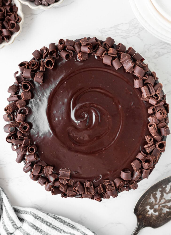 A cake decorated with chocolate ganache frosting and chocolate curls