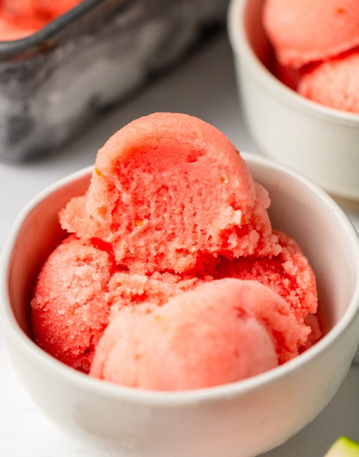 A bite taken from a scoop of watermelon ice cream