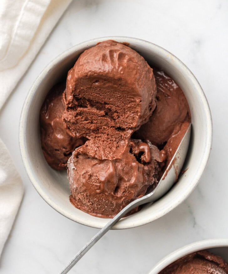 Chocolate ice cream in a ceramic dish with a spoon