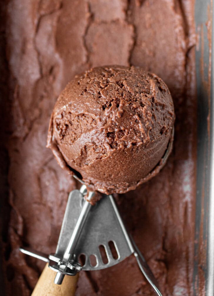 A scoop of chocolate ice cream in an ice cream scoop