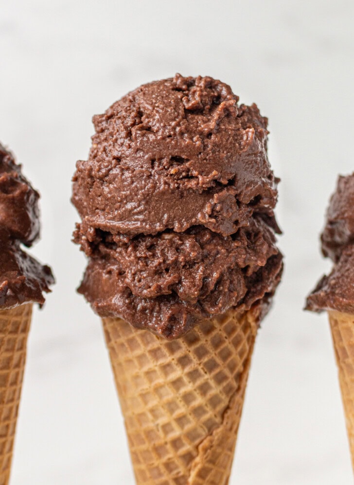 Two scoops of chocolate ice cream in a waffle cone