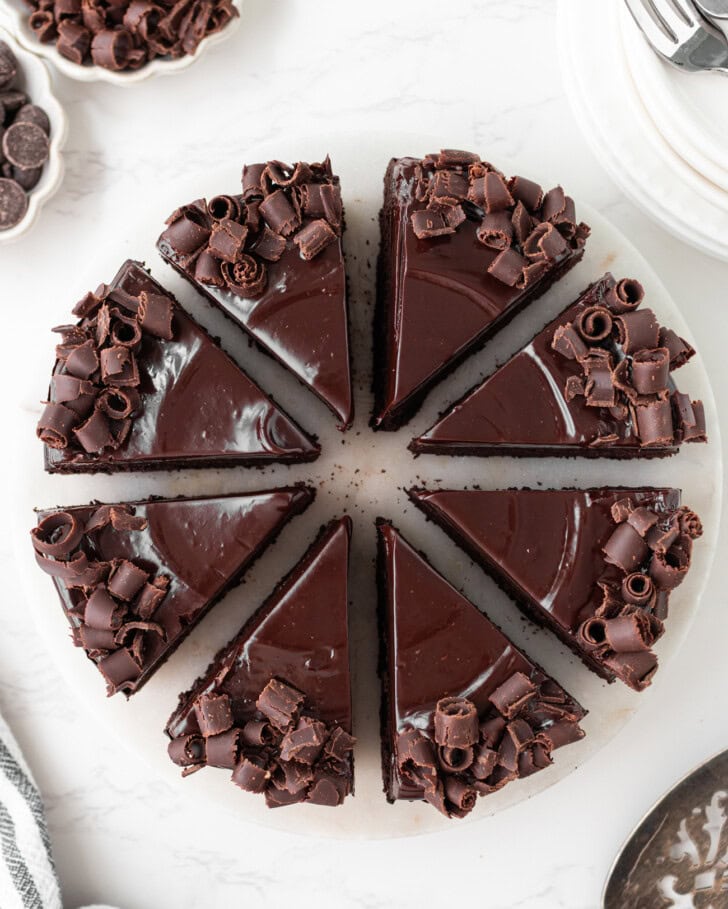 A chocolate cake decorated with chocolate ganache frosting and chocolate curls