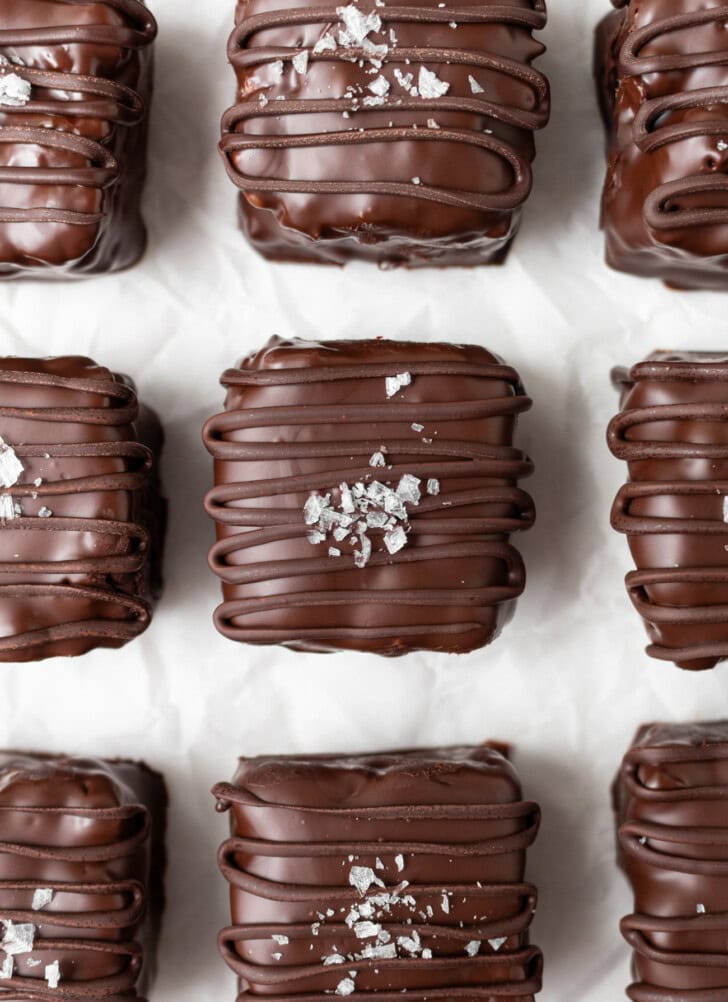 Candy bar squares with a chocolate drizzle and coarse salt on top