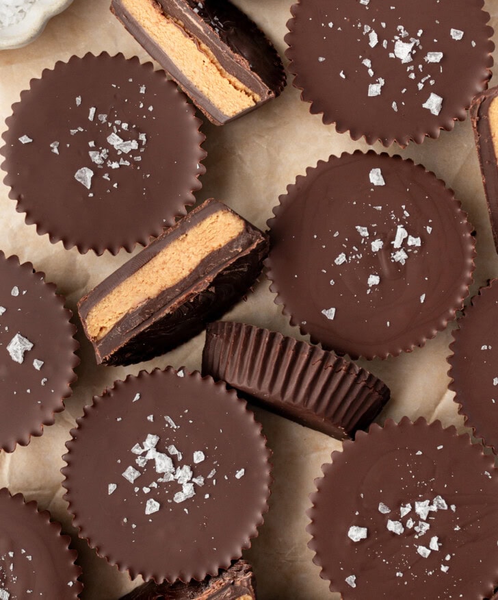 Chocolate peanut butter cups with some cut in half and coarse salt on top